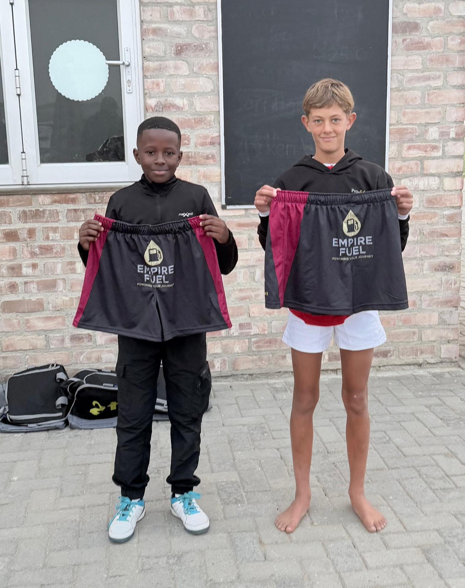 Young rugby players holding their Empire Fuel-sponsored playing shorts
