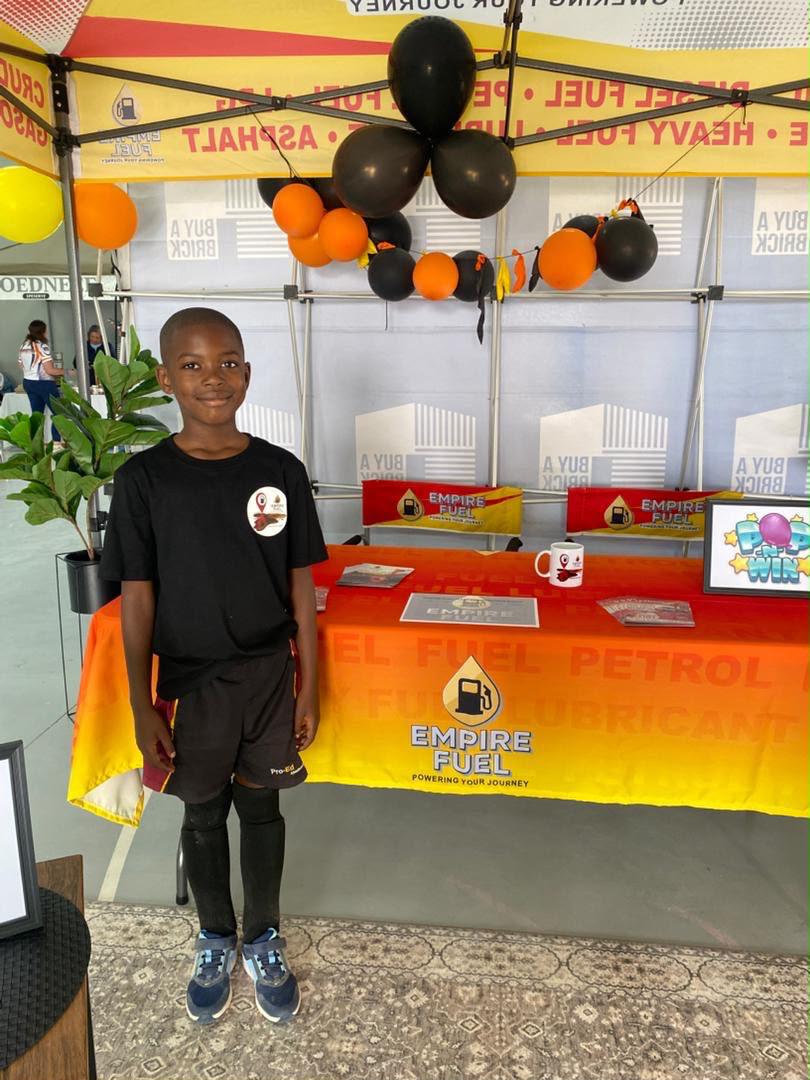 A young player in his Empire Fuel-sponsored kit at the community stand